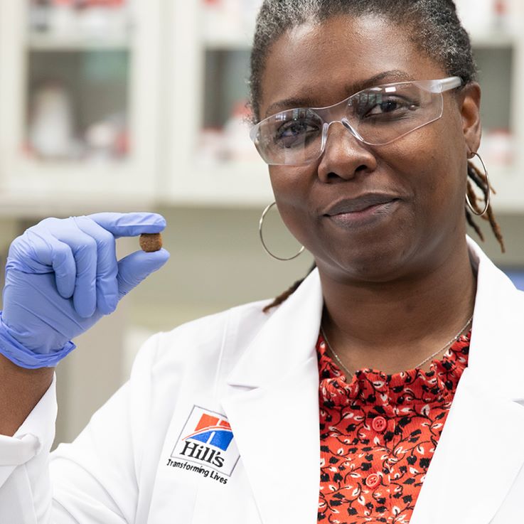 Η ερευνήτρια Hill's Pet Nutrition κρατά την τροφή Hill's Pet στο χέρι της